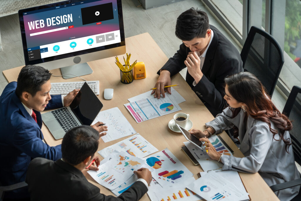 Business team discussing web design strategies with charts and analytics on the table.